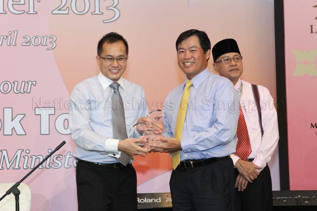 President of AIN Society Mr Abdul Malek Osman presenting a plaque as a token of appreciation to Tote Board and Singapore Pools