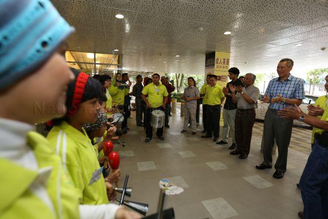 Prime Minister Lee Hsien Loong, Member of Parliament (MP) for Sembawang GRC Mr Hawazi Daipi, and Member of Parliament (MP) for Sembawang GRC Mr Vikram Nair enjoying a welcoming performance at the opening of the new Woodlands Galaxy Community Club.