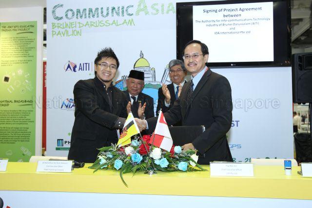 Signing of Memorandum of Understanding between Brunei's PHMD Publishing Company and Singapore's LDR Pte Ltd at the Brunei Pavilion in CommunicAsia, an event incorporated under Infocomm Media Business Exchange (imbX) at Marina Bay Sands. Brunei's PHMD Publishing Company Chief Executive Officer Mohd Khairi Pengiran Haji Metussin (front row, left) shaking hands with Singapore's LDR Pte Ltd Chief Executive Officer Png Bee Hin (front row, right). Witnessing the signing are Brunei's Minister of Communications Yang Berhormat Pehin Orang Kaya Hamzah Pahlawan Dato Seri Setia Awang Haji Abdullah bin Begawan Mudim Dato Paduka Haji Bakar (back row, left) and Minister for Communications and Information Dr Yaacob Ibrahim (back row, right).