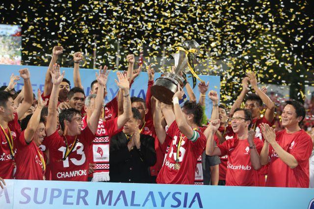 Lions XII football players celebrating after football match between LionsXII and Felda United in the final round of Malaysian Super League 2013 held at Jalan Besar Stadium. Also present is Football Association of Malaysia (FAM) general-secretary Hamidin Amin (wearing black coat, beside Prime Minister Lee).