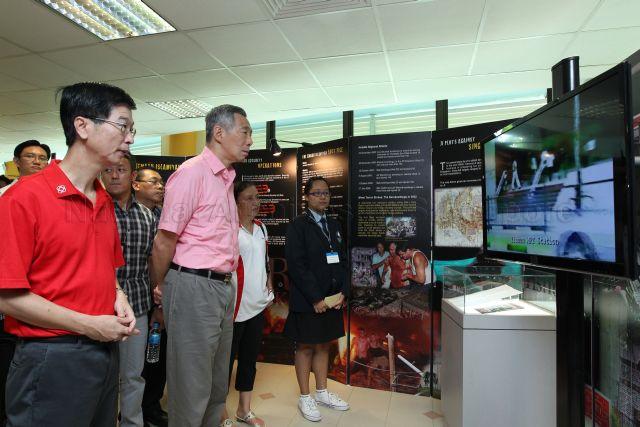 Prime Minister Lee Hsien Loong visiting Internal Security Department (ISD) Heritage Centre mobile exhibition on security threats at Chong Boon Secondary School in Ang Mo Kio Street 44. On the left is Chief Executive Director of People's Association Ang Hak Seng.