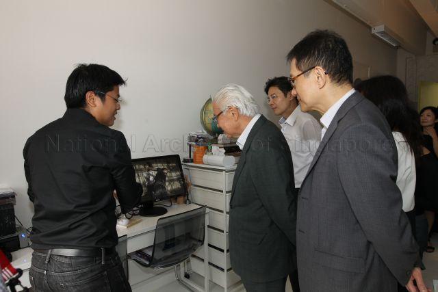 Local multi-disciplinary artist Brian Gothong Tan (left) explaining the significance of an artistic display to President Tony Tan (centre) at Goodman Arts Centre.