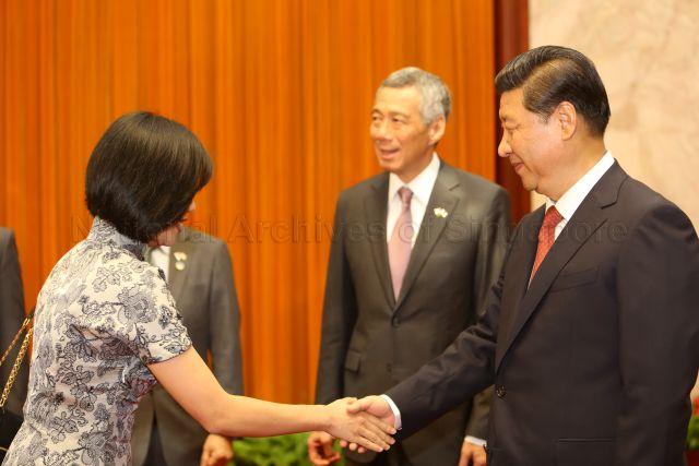 Chinese President Xi Jinping is shaking hands with Senior Parliamentary Secretary to the Minister for Communications and Information Sim Ann at the Great Hall of the People in Beijing. Also present is Prime Minister Lee Hsien Loong. This is a picture taken during Prime Minister Lee Hsien Loong’s seven-day official visit to China.
