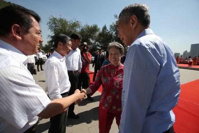 Madam Ho Ching is shaking hands with a Chinese government official at Hongshan Park at Urumqi. Also present is Prime Minister Lee Hsien Loong (right, side facing camera). This is a picture taken during Prime Minister Lee’s seven-day official visit to China.