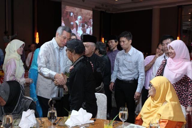 Prime Minister Lee Hsien Loong at launch of book "A Village Remembered - Kampong Radin Mas 1800s to 1973", shaking hands with a guest. &nbsp;Looking on is (on the left of PM Lee) Mr Wan Hussin Zoohri (former Member of Parliament and Chairman of Book Project Committee).