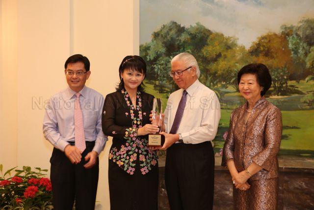 Award recipient Mdm Chee Mui Choo (from Xinghua Primary) receiving her President's Award for Teachers from President Tony Tan at the Teachers' Day reception. Looking on are Minister of Education Heng Swee Keat (on the left) and (4th from left) Mrs Mary Tan (wife of President Tony Tan). The event is held at the Istana.