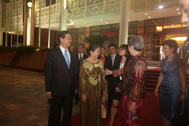 On the left is Vietnamese Prime Minister Nguyen Tan Dung looking on while his wife Tran Thanh Kiem is conversing with Madam Ho Ching (wife of Prime Minister Lee Hsien Loong) after the official dinner hosted by PM Nguyen during PM Lee's three-day official visit to the Socialist Republic of Vietnam. &nbsp;Also looking on is (on the right) Grace Fu (Minister in the Prime Minister's Office and Second Minister for Foreign Affairs and the Environment and Water Resources) and (4th from right) Pham Binh Minh (Vietnamese Minister for Foreign Affairs) The dinner is held at the International Conference Centre.
