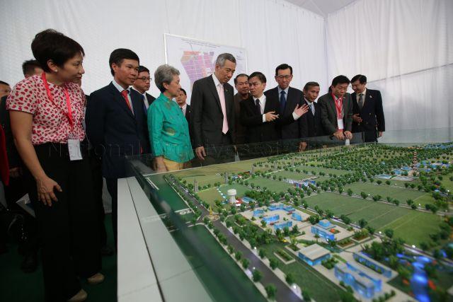 Prime Minister Lee Hsien Loong and his wife Madam Ho Ching being shown the model of the fifth VSIP by (8th from left) co-Chairman of Vietnam-Singapore Investment Park (VSIP) Group and Chief Executive Officer of Sembcorp Development Kelvin Teo, during ground-breaking ceremony for the (VSIP) in Quang Ngai Province. Also present are Minister in the Prime Minister's Office and Second Minister for the Environment and Water Resources and Foreign Affairs Grace Fu (on the left), Singapore Ambassador to Vietnam Ng Teck Hean (3rd from left), Sembcorp Group President and Chief Executive Officer Tang Kin Fei (9th from left), Senior Minister of State for National Development and Trade and Industry Lee Yi Shyan (11th from left) and Member of Parliament (Jurong) Ang Wei Neng (12th from left). PM Lee is on a three-day official visit to the Socialist Republic of Vietnam.