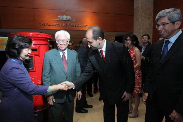 General Manager of Fullerton Hotel Cavaliere Giovanni Viterale shaking hands with Mrs Mary Tan, wife of President Tony Tan, during Singapore Post "Gift to the Nation" presentation ceremony, held at Heritage Gallery of Fullerton Hotel. Looking on are President Tan and (on the right) Minister for Communications and Information Assoc Prof Dr Yaacob Ibrahim.