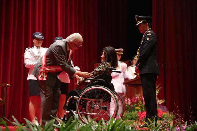 President Tony Tan Keng Yam presenting Public Service Medal to President of Society for the Physically Disabled (SPD) Miss Chia Yong Yong at investiture of National Day awards held at University Cultural Centre Hall, National University of Singapore in Kent Ridge