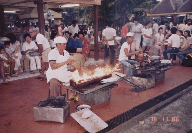Stallholders making satay at Satay Club, an open-air food centre<br />