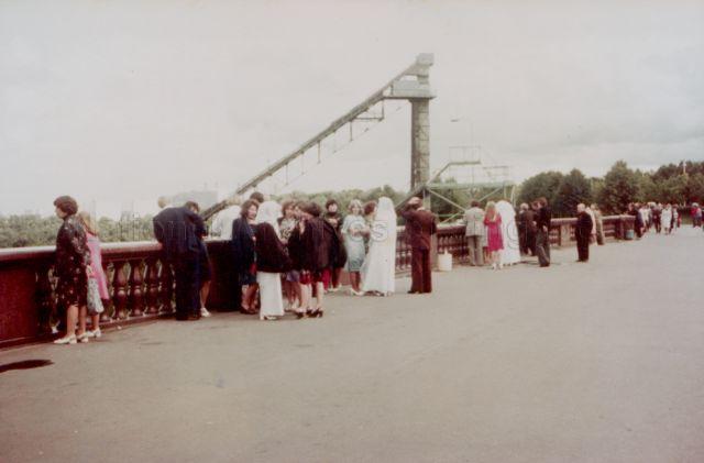 Photograph of a balcony in Moscow with several wedding groups posing for photographs