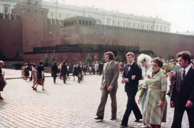 Photograph of a Caucasian wedding couple and family walking along a crowded pedestrian mall in Moscow<br />
