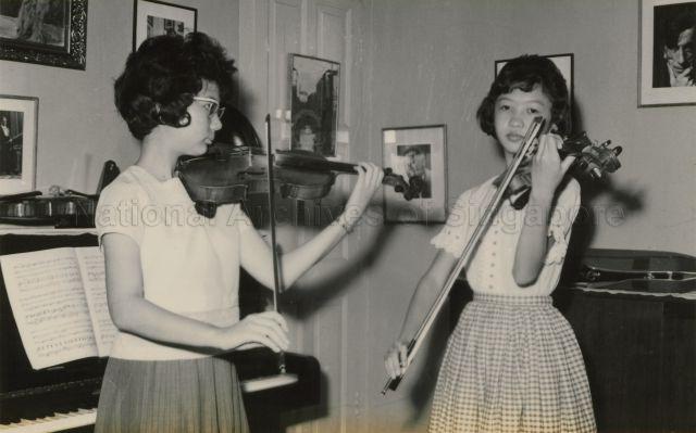 Patricia Lee and Magdalene Chan, Goh Soon Tioe's students, on the violin rehearsing.