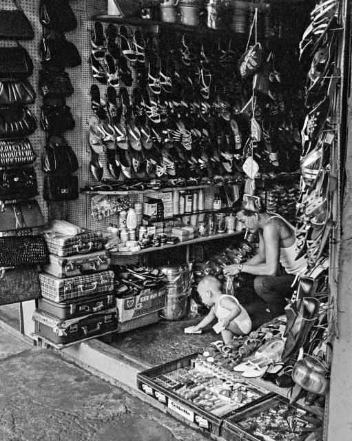 A little boy helping his father to keep the shop clean