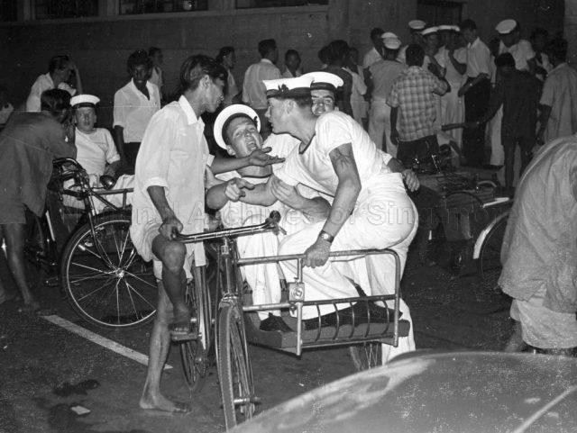 Photograph of sailors taking a trishaw at Bugis Street.