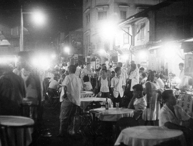 Photograph of brightly lit food stalls on Bugis Street.