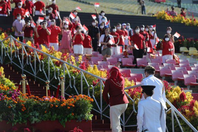 Taken at: National Day Parade (NDP) ceremonial parade at The Float @ Marina Bay Pictured: President Halimah Yacob (back facing camera)