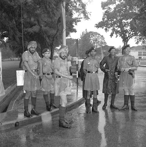 Policemen Brave the Heavy Rain during Singapore's first National Day Mass Rally and March-past at the Padang