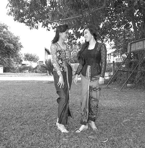 Fashion models pose on the grounds of Tanjong Katong Girls' School. &nbsp;The models are wearing traditional Malay costume called the sarong kebaya. &nbsp;It is a two-piece dress comprising a sarong wrapped around the waist and a see-through blouse usually made from Swiss voile material. &nbsp;The sarong kebaya differs in design from the Pernakan dress.