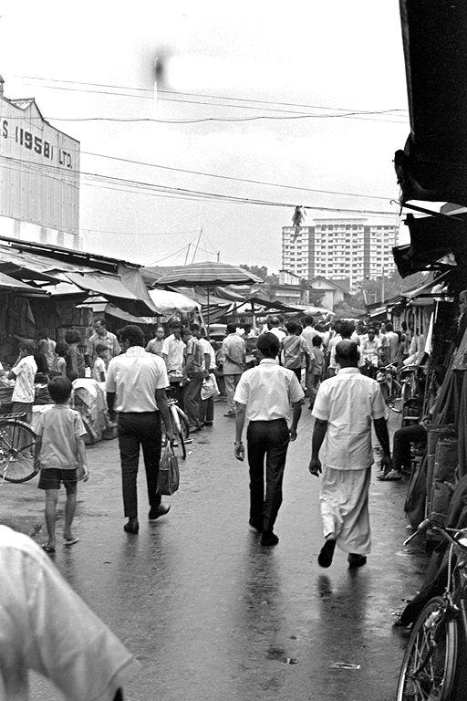 View of people shopping at second-hand stalls along Sungei Road. On the left is the Singapore Ice Works (1958) Limited.