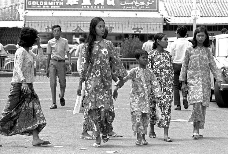 Shoppers walking in front of Block 2 Jalan Pasar Baru. In the background is a row of shops lining Geylang Serai.
