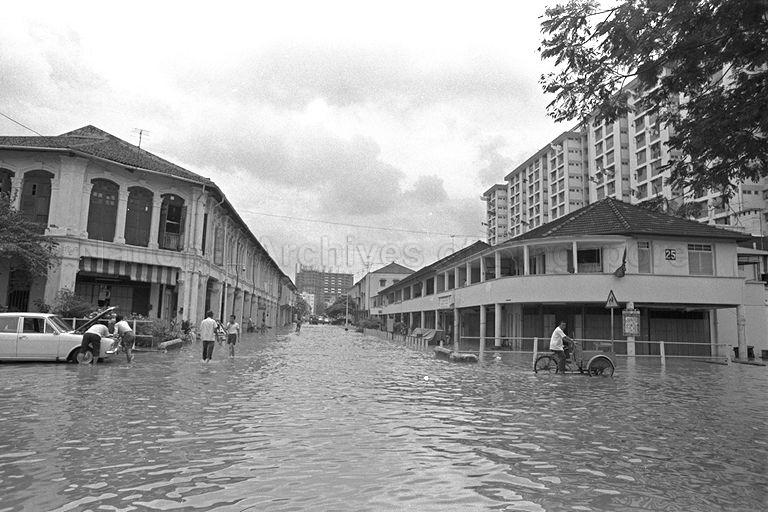 Flood waters at the junction of Owen Road and Dorset Road. The building under construction in the background (centre) is the former New Park Hotel which is now the Parkroyal Hotel on Kitchener Road. 